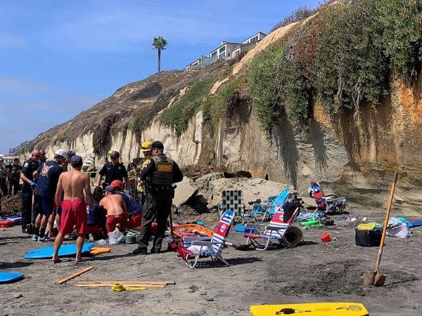 Emergency responders attend to a cliff collapse