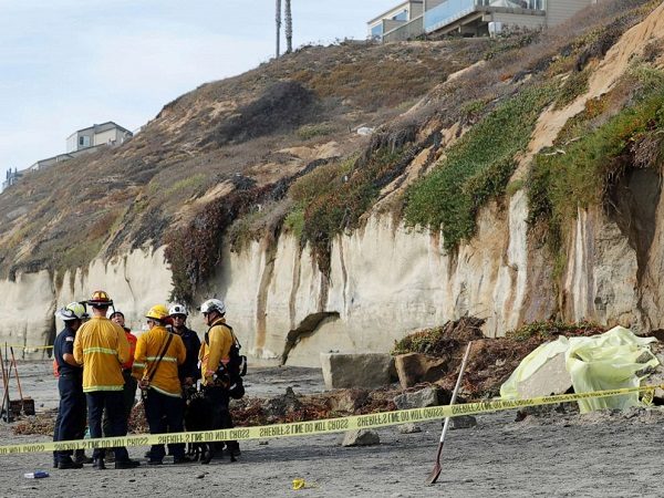 Click to enlarge Emergency responders attend to a cliff collapse