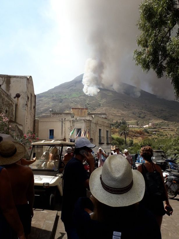 Click to enlarge Holidaymakers gathered as the Stromboli volcano erupts and sends an ash cloud into the sky