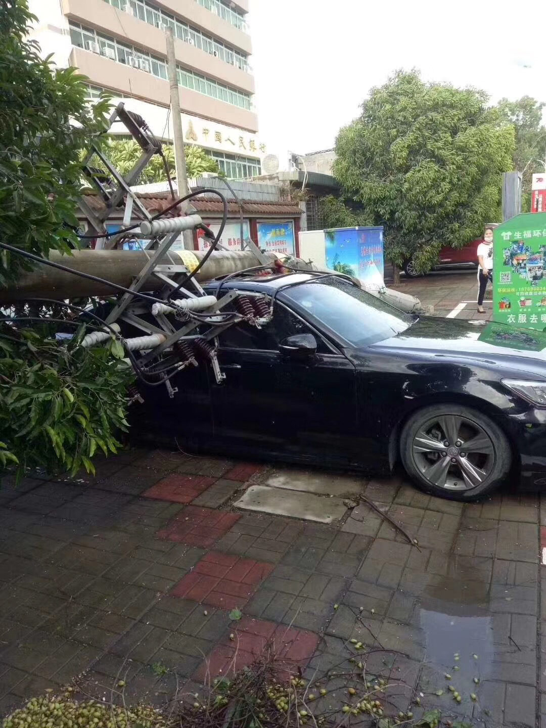 A car is hit by a utility pole blown down by a sudden tornado in Nada town of Danzhou, South China's Hainan province, Aug 29, 2019.
