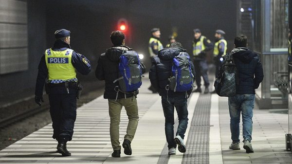 Police officer escorts migrants