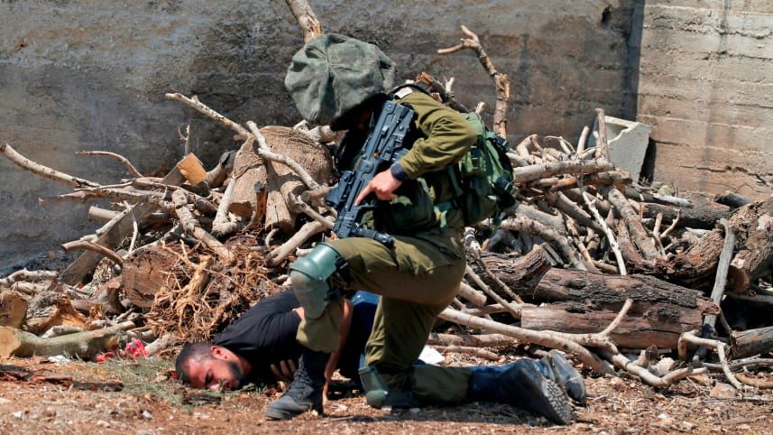 Click to enlarge Israeli soldier detains Palestinian
