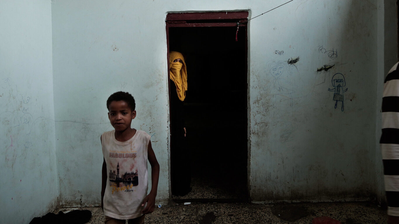 People walk in a shelter for displaced persons in Ibb, Yemen