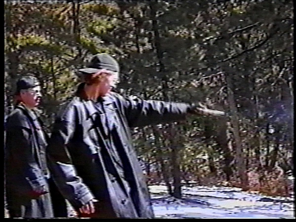 Eric Harris (L) watches as Dylan Klebold practices shooting a gun at a makeshift shooting range