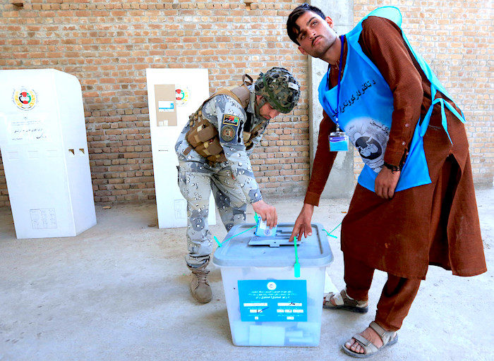 Click to enlarge Afghan policeman votes