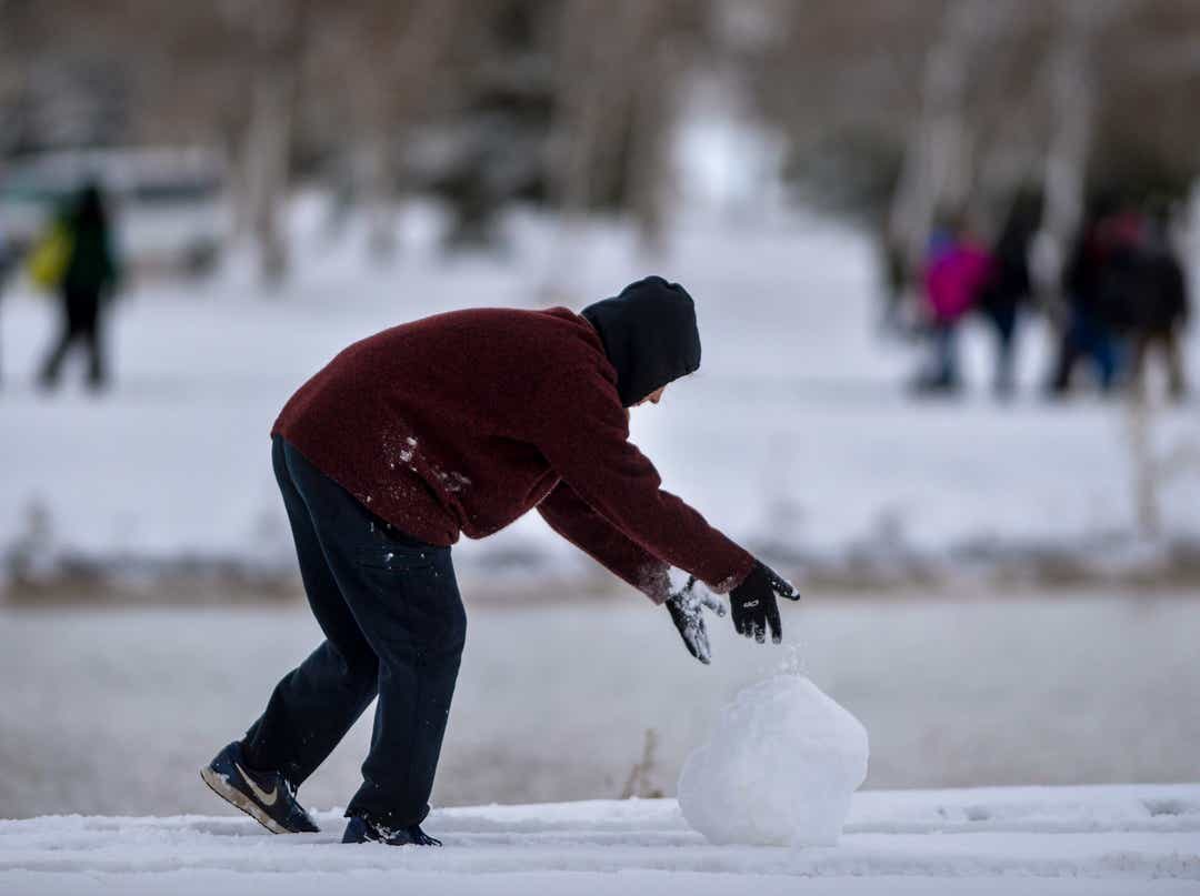 Maya Carvey, a runner from Eureka, passes the time before her race by working on a snowman during the state cross country meet at Eagle Falls Golf Course in Great Falls, Saturday, October 26, 2019.