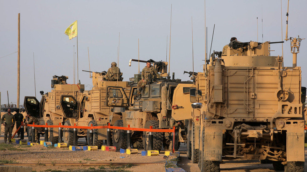 American soldiers stand near military trucks