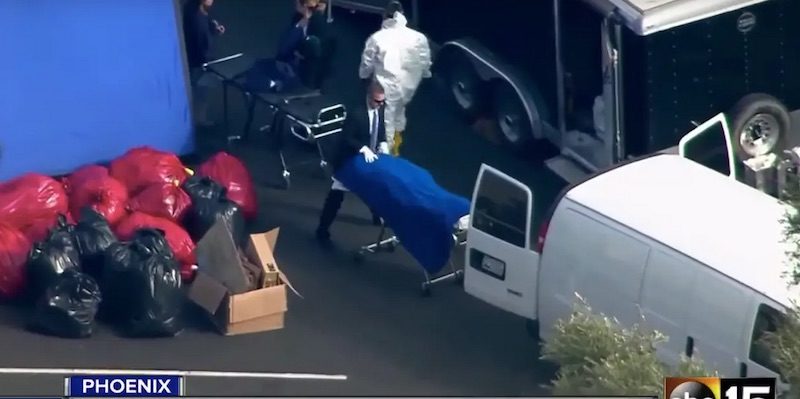 An FBI agent wheels a trolley into a van at the Biological Research Center in Phoenix, Arizona.