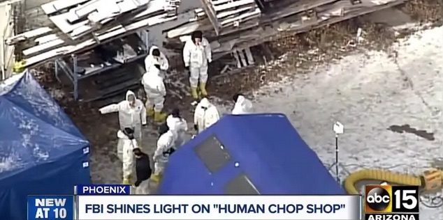 Click to enlarge People in hazmat suits stand outside the Biological Research Center in Phoenix.