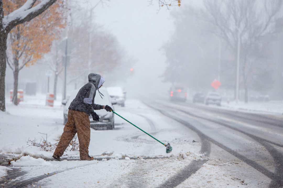 Steven Holston of Detroit helps out an aging family member by managing their snow on E. Grand Blvd. as snow hit the region Monday, Nov. 11, 2019.