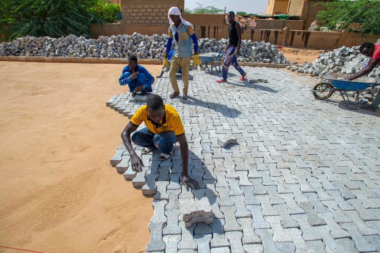men bricks pave road