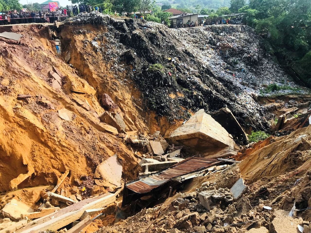 Residents stand near the scene of a landslide following torrential rains near the University of Kinshasa, in the Democratic Republic of Congo November 26, 2019.