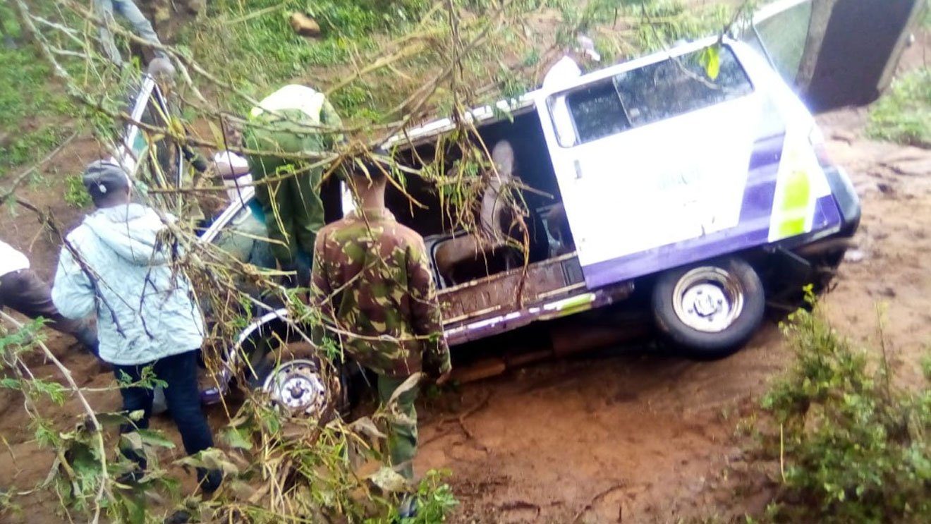 Members of the public mill around the vehicle in which five family members died after being swept away by flash floods