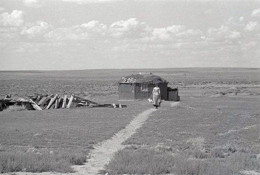Navajo woman walks towards her hogan