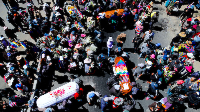 Mourners carry the coffins