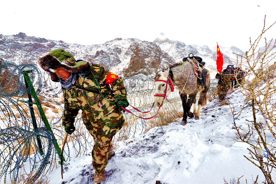 Braving the cold, police officers and civil border guards patrol a ranch on the border with Mongolia in Changji, Xinjiang Uygur autonomous region, on Sunday