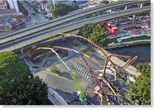 Cranes are deployed in Guangzhou, the capital of Guangdong province, after a road collapsed near a construction site on Sunday morning.