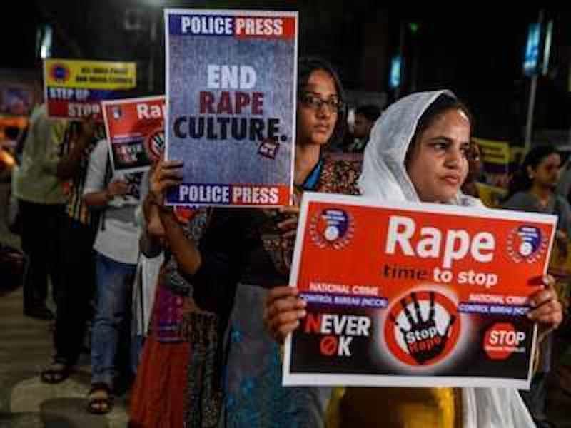 Demonstrators hold placards to protest against sexual assaults