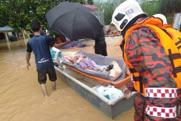 Personnel from the Johor Fire and Rescue Department yesterday helping to move people with disabilities
