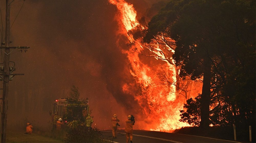 Firefighters, many of them volunteers, are battling around 100 fires that have encircled Sydney amid drought and record-high temperatures