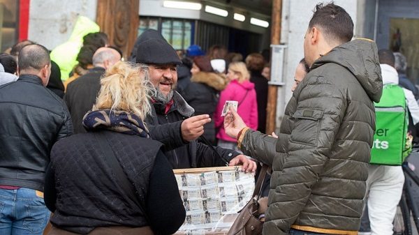 Click to enlarge A man buys a Christmas lottery ticket