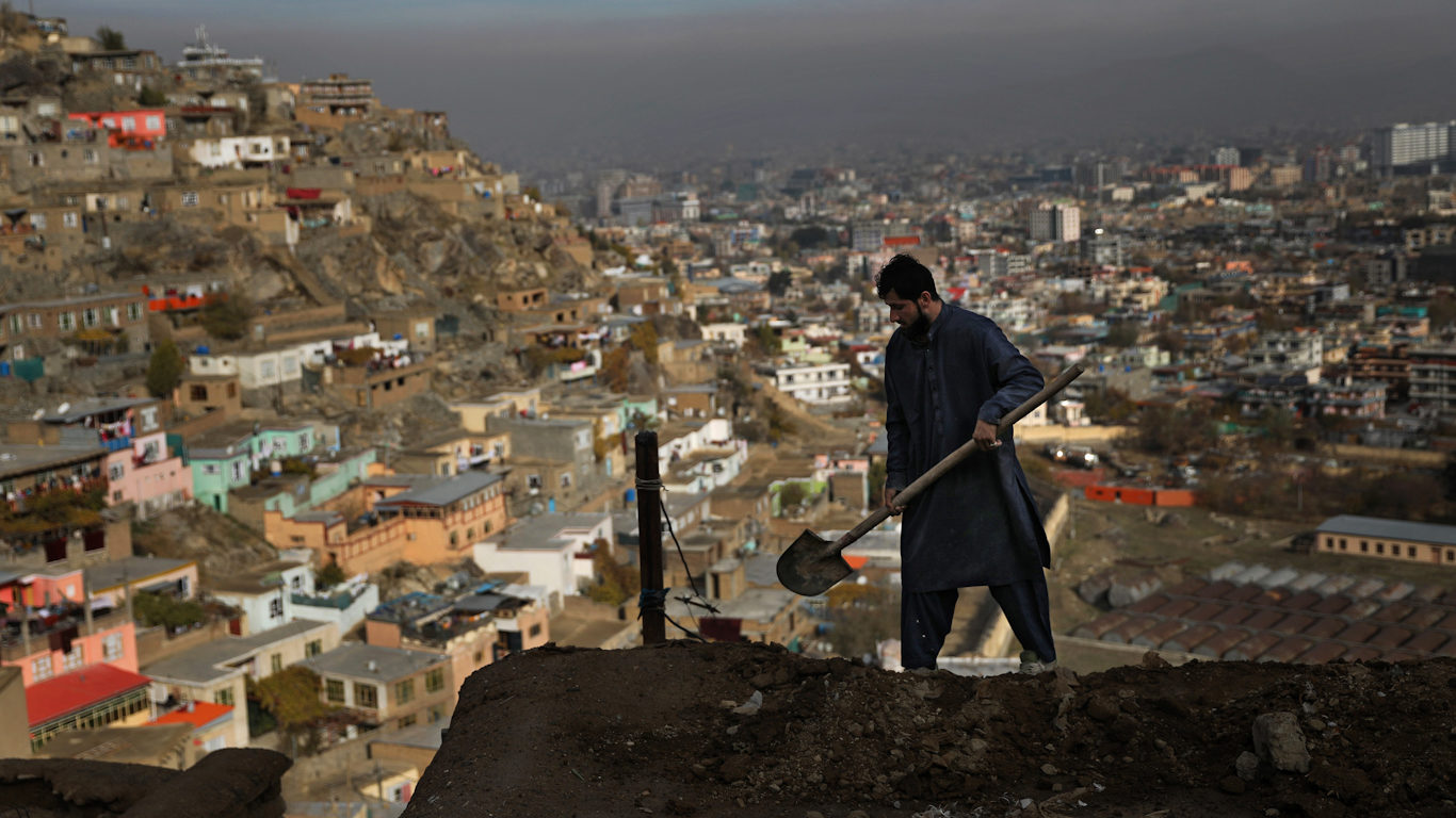 Click to enlarge Afghan man repairing roof