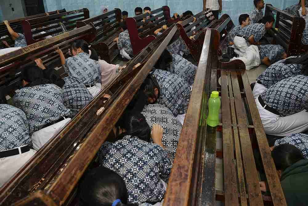 Indonesian students take cover during an earthquake and tsunami drill at a school in Banda Aceh November 14, 2019