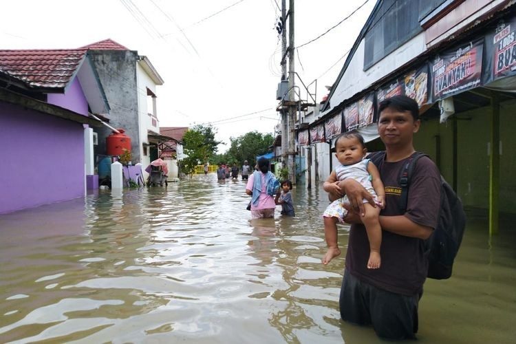 Click to enlarge Residents of Bengkuring in Sempaja Timur, Samarinda, flee their homes because of flooding on Tuesday.