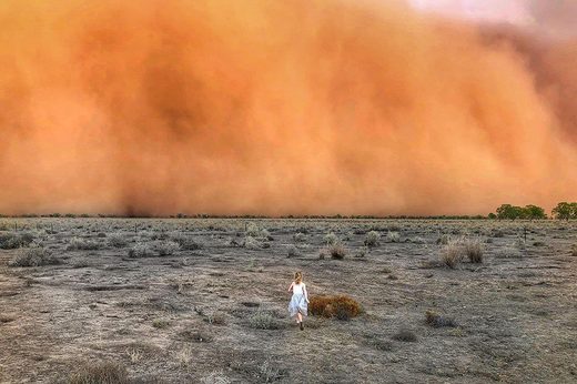 Child running towards a dust storm in Mullengudgery in New South Wales.
