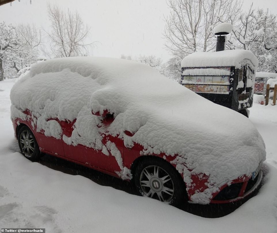 A car is pictured covered in snow after stormy weather hit Albacete in Castilla La Mancha, Spain