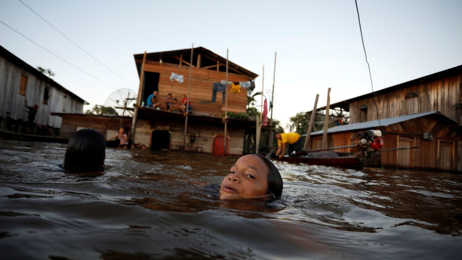 A child swims through a flooded street in Anama, Amazonas state