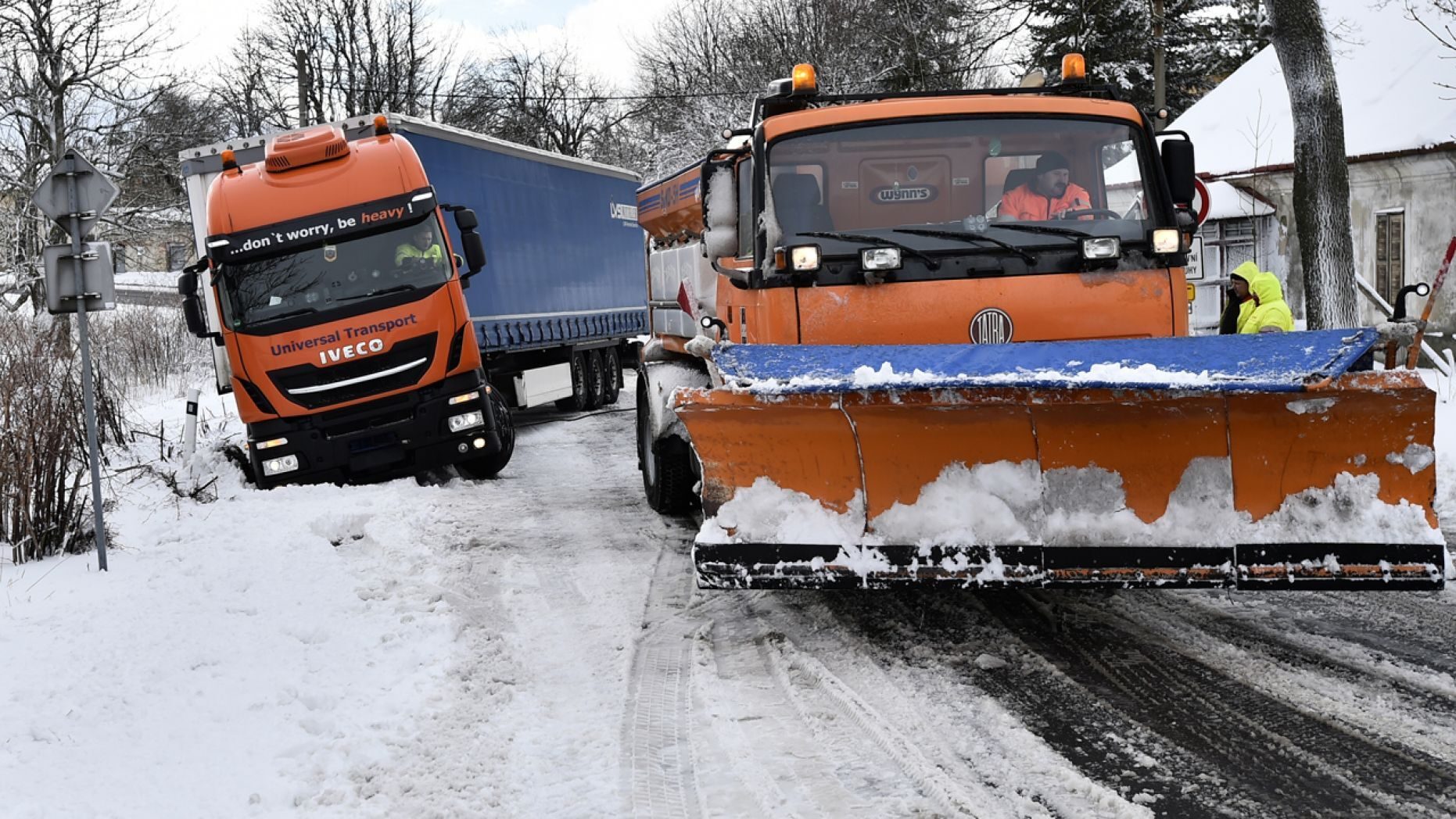 A snowplow pulls a truck stranded along a snow-covered road in the village of Naklerov, Czech Republic, Wednesday, Feb. 5, 2020.
