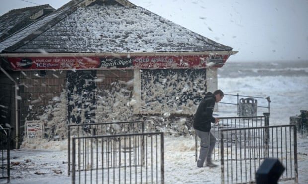 Click to enlarge High winds from Storm Ciara whip up foam onto the road at Caswell Bay near Swansea