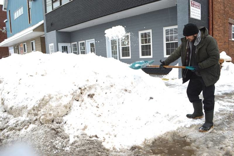 Nathan Quinn of Alder Point clears the sidewalk in front of J. Francis Investments on George Street, Sydney, Friday. A record 179.8 cm of snow was registered at the Sydney airport in January, the most since records have been kept dating back to 1870.