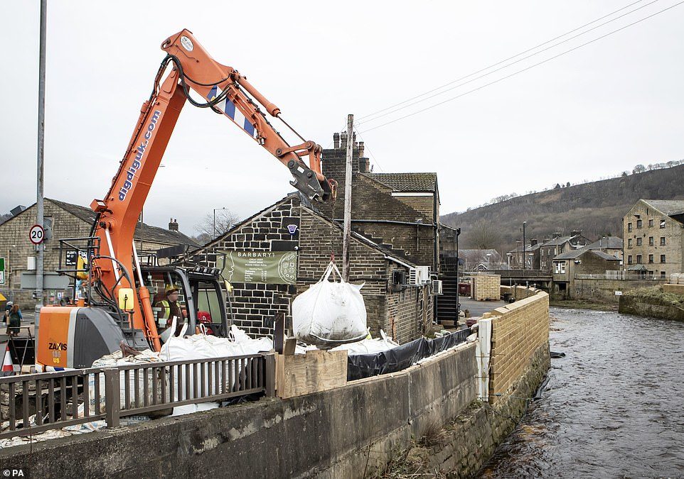 Click to enlarge Yesterday in Mytholmroyd, West Yorkshire, officials were seen desperately trying to prepare for Storm Dennis by using sandbags as flood defences