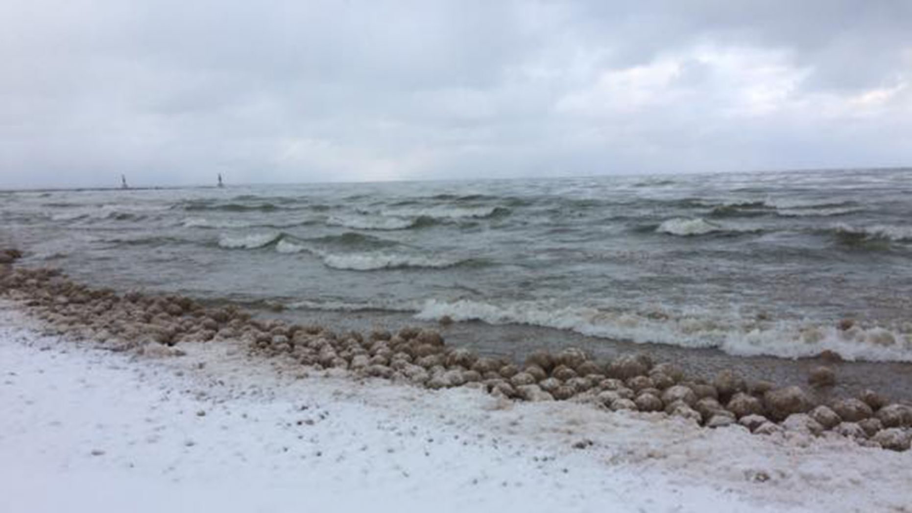 Click to enlarge Thousands of ice balls formed and washed along the shore of Lake Michigan on Friday.