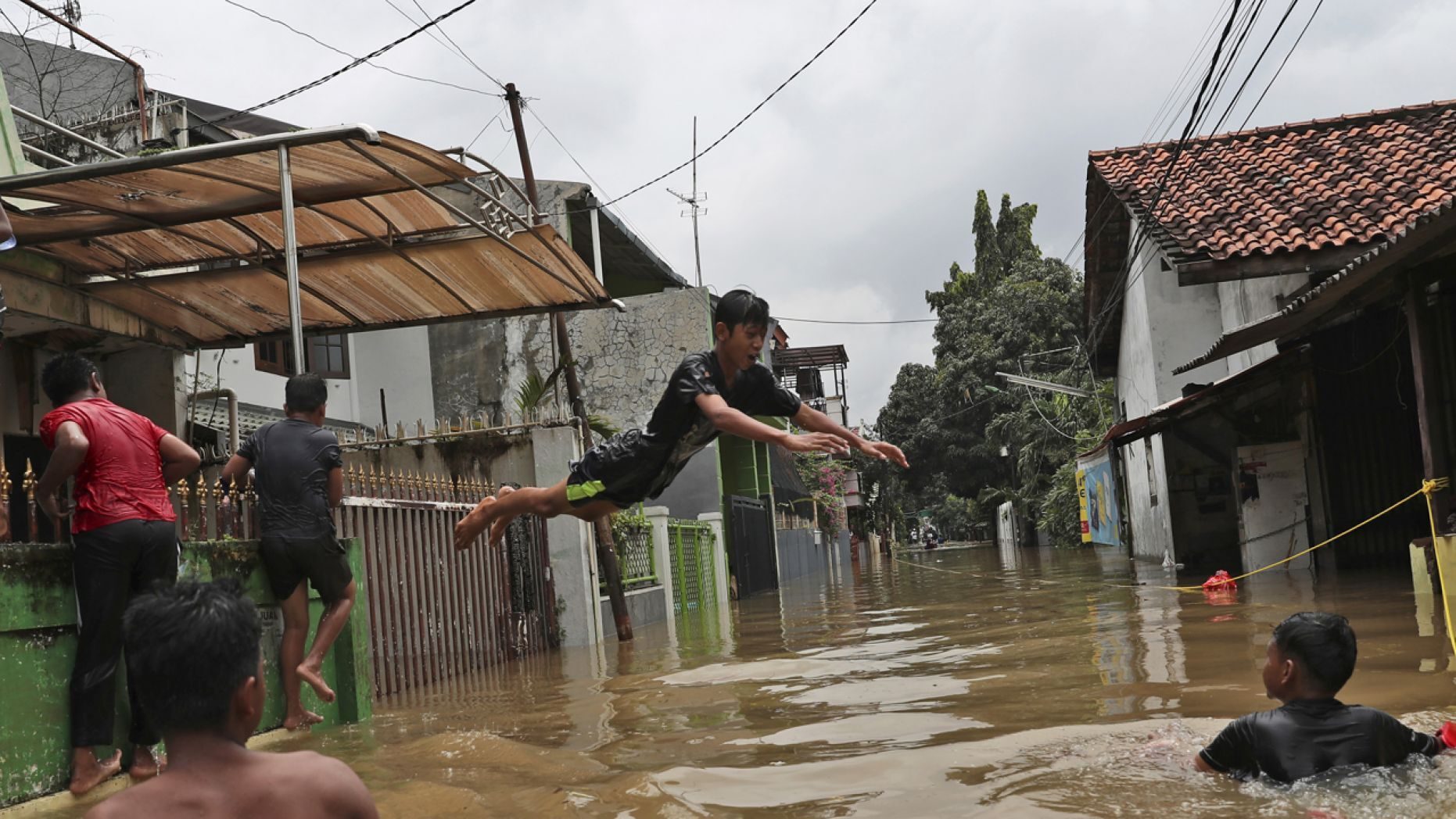 Click to enlarge Indonesian youths play in flood water in a community in Jakarta, Indonesia, Tuesday, Feb. 25, 2020.