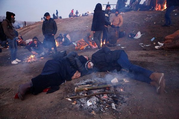 Migrants sleep in a field