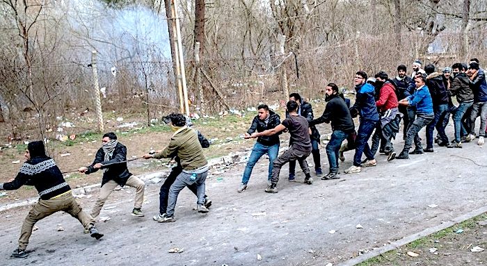 Click to enlarge Migrants pull fence