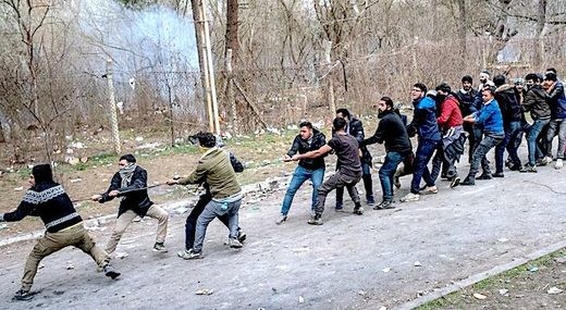 Click to enlarge Migrants pull fence