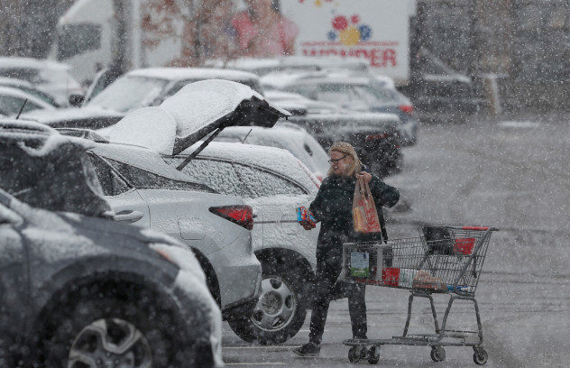Click to enlarge A shopper loads groceries into her sports-utility