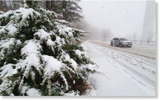Click to enlarge A car passes through the snow-covered