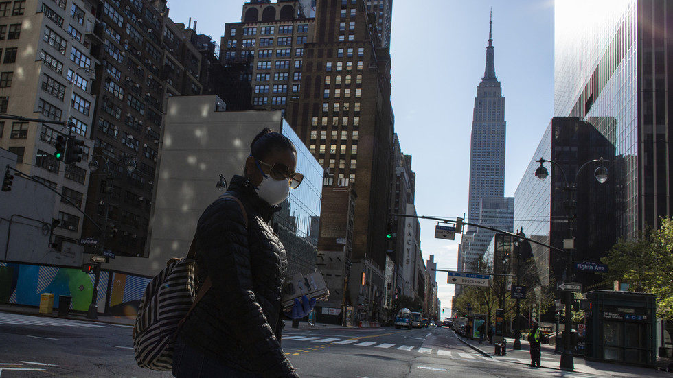 Click to enlarge A woman wearing a mask crosses 34th street on April 6, 2020 in New York City