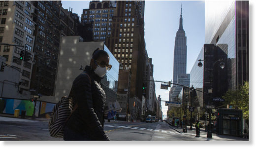 A woman wearing a mask crosses 34th street on April 6, 2020 in New York City