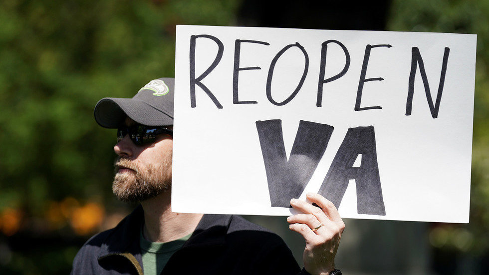 demonstrator holds a sign in opposition to Virginia's stay-at-home order