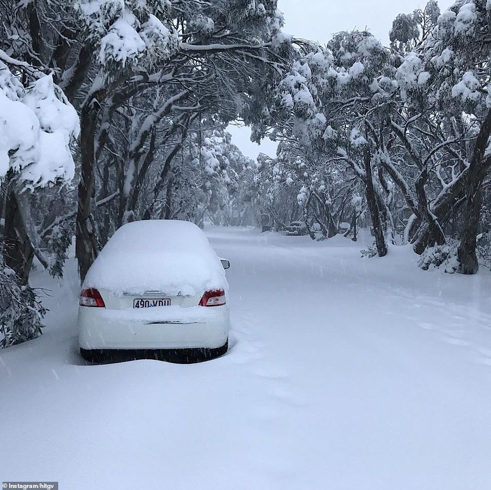 Snow blankets a road in Mount Buller in Victoria with footprints seen on the path. Blizzard conditions are expected across all of the state’s Alpine region, bringing up to 50cm of snow by the weekend