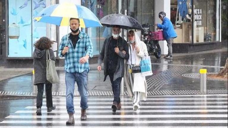 People cross the road in rainy Tel Aviv