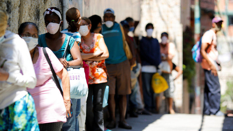 Click to enlarge People make a line to receive food from a charity in Caracas