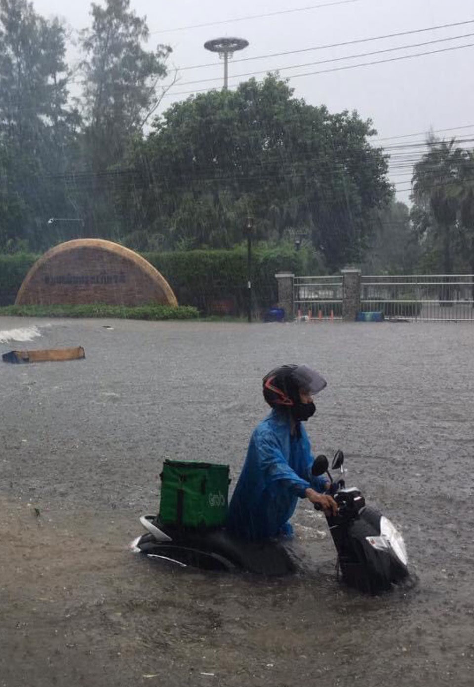 A food delivery man tries to move his bike through floodwater in front of Chalerm Phrakiart park in Muang district of Phuket on Saturday morning.