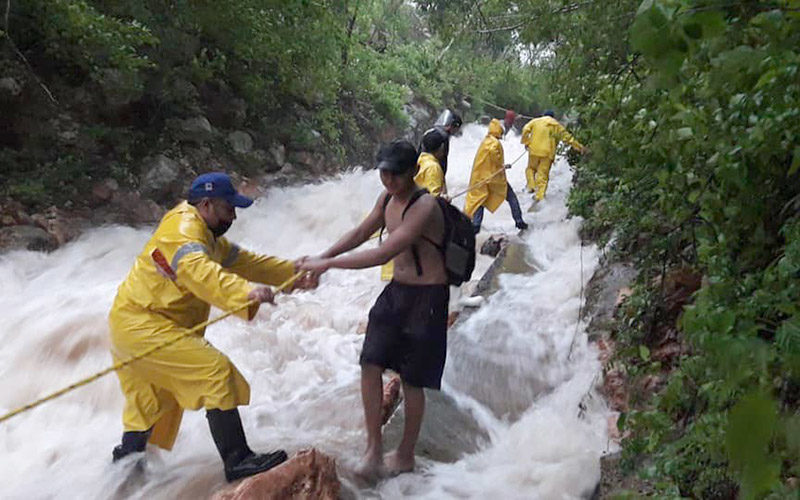 Floods form a raging river in Tekax, where police rescue stranded residents.